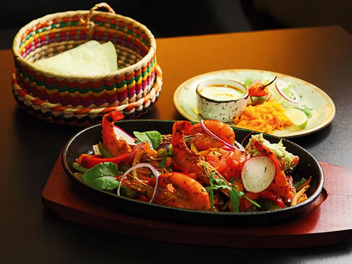Shrimp fajita in a skillet with tortillas