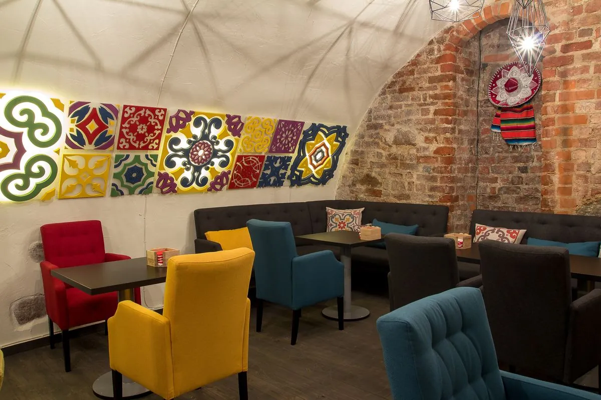 Salė su spalvingomis kėdėmis ir talavera plytelėmis