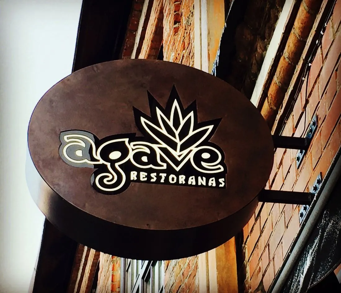 Apvali Agave iškaba ant plytų sienos